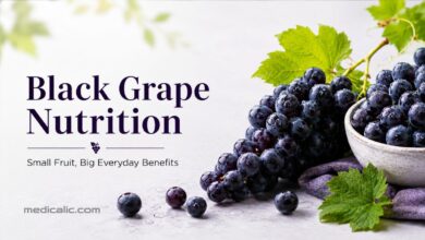 Fresh black grapes with green leaves and water droplets showing everyday nutrition benefits